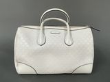 a white handbag sitting on top of a gray surface