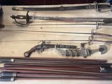 de nombreux types d'armes exposés sur une table