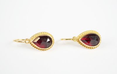 a pair of red garnet stone earrings on a white background