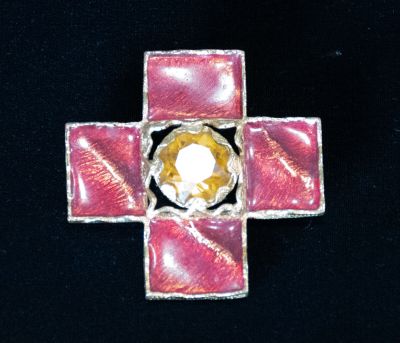 a pink cross with a yellow center on a black background