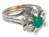 une image d'une bague avec une pierre verte entourée de diamants