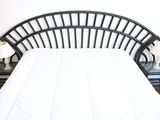 a white bed with a black headboard and two night stands