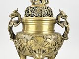an image of a brass vase with two birds on top of it