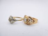 two gold and silver rings with diamonds on a white surface