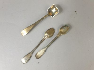 trois cuillères et un repose-cuillère posés sur une table