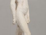 statue of a woman standing on a pedestal on a table