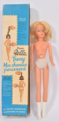 une poupée Barbie dans une boîte, à côté d'un carton sur lequel figure la photo d'une femme en maillot de bain