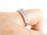 a woman ' s hand holding a diamond ring on her finger