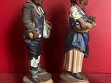 two figurines of a man and a woman standing next to each other