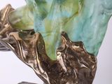 statue of a woman holding a leaf on a base with a white background