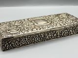 une boîte en argent dont le couvercle est orné d'un motif floral