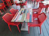 many red chairs and tables on the deck