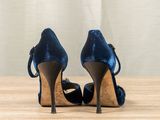 blue high heeled shoes on a wooden table with a curtain in the background