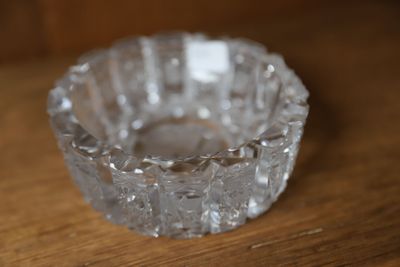 un saladier en verre transparent posé sur une table en bois