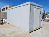 an image of a white portable toilet sitting in the middle of a dirt field