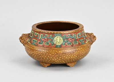 un petit pot orné d'un motif sur le côté extérieur
