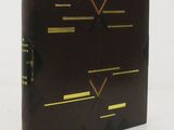 the book is brown with gold trimmings and a black cover