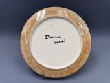 une assiette blanche avec un bord marron sur fond bleu