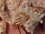 a close up of a doll with lace on it ' s arms