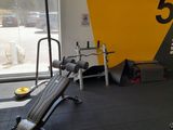 une salle de sport avec un banc, des poids et d'autres équipements