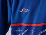 a close up of a blue shirt with autographs on it