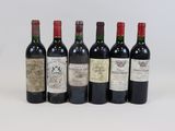 six bottles of wine are lined up in a row on a white surface