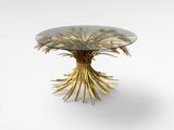 une photo d'une table en verre ornée de feuilles d'or