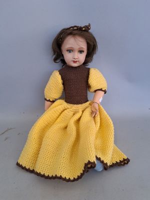 poupée au crochet jaune, avec une robe et des chaussures marron