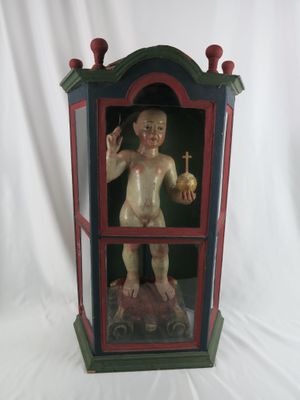 a small statue of a baby in a glass case