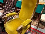 une chaise jaune au milieu d'une pièce remplie de meubles anciens