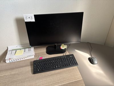 a computer desk with a keyboard, mouse, and monitor