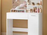 une coiffeuse blanche avec un miroir et des flacons de parfum posés dessus