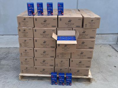 several boxes of cigarettes are stacked on a pallet in front of a wall