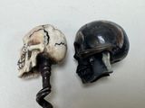 two wine corks with a skull head on them