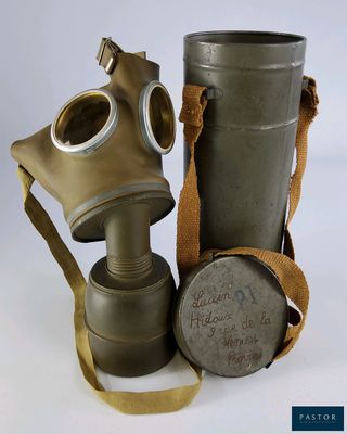 un vieux masque à gaz et une cartouche posés sur une surface blanche