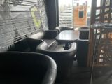 two black chairs and a table in the corner of a room