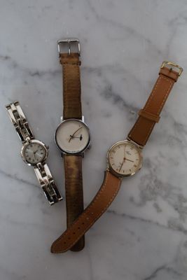 trois montres sont posées les unes à côté des autres sur une surface en marbre