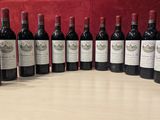 six bouteilles de vin rouge alignées sur une table en bois