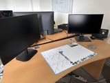 a desk with two monitors and a keyboard on it