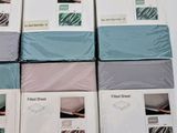 six boxes of bed sheets stacked on top of each other on a table
