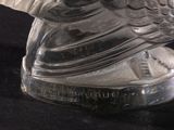 a glass sculpture of a bird on a black surface