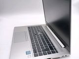 a silver laptop computer sitting on a white surface