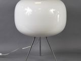 a white lamp that is on a metal stand