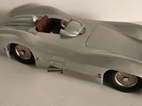 an image of a silver toy car sitting on top of a white table