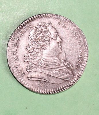 a close up of a coin on a green surface