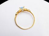 an image of a gold ring with a blue stone in the center