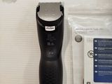 a black shaver with a white blade next to a plastic bag