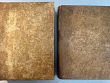 two old books that are sitting on a table