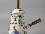 a tea pot with a wooden handle and a bird on it
