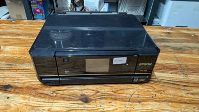 the printer is sitting on top of the wooden table in the room